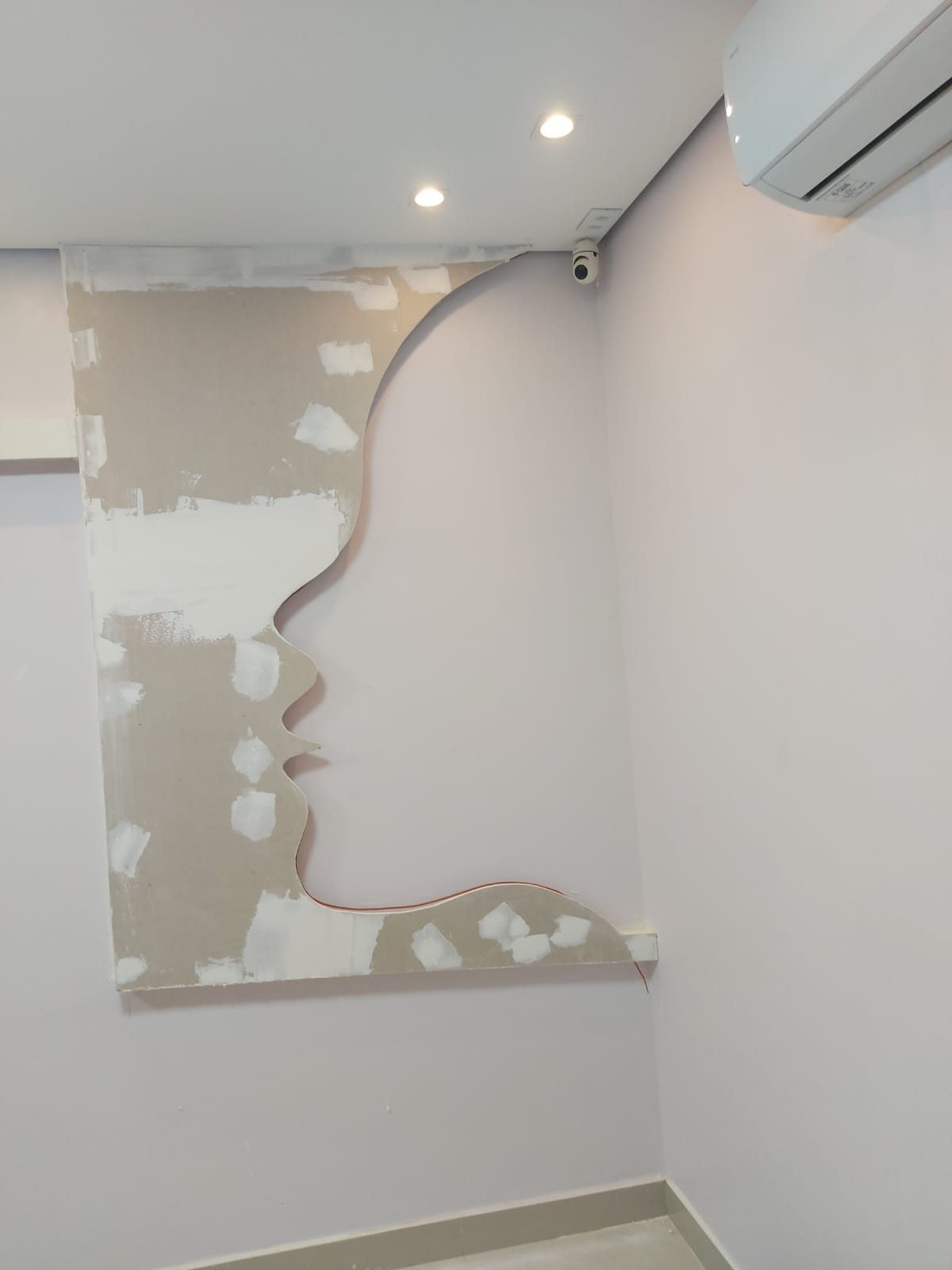 Painel de drywall recortado em formato de perfil de rosto
